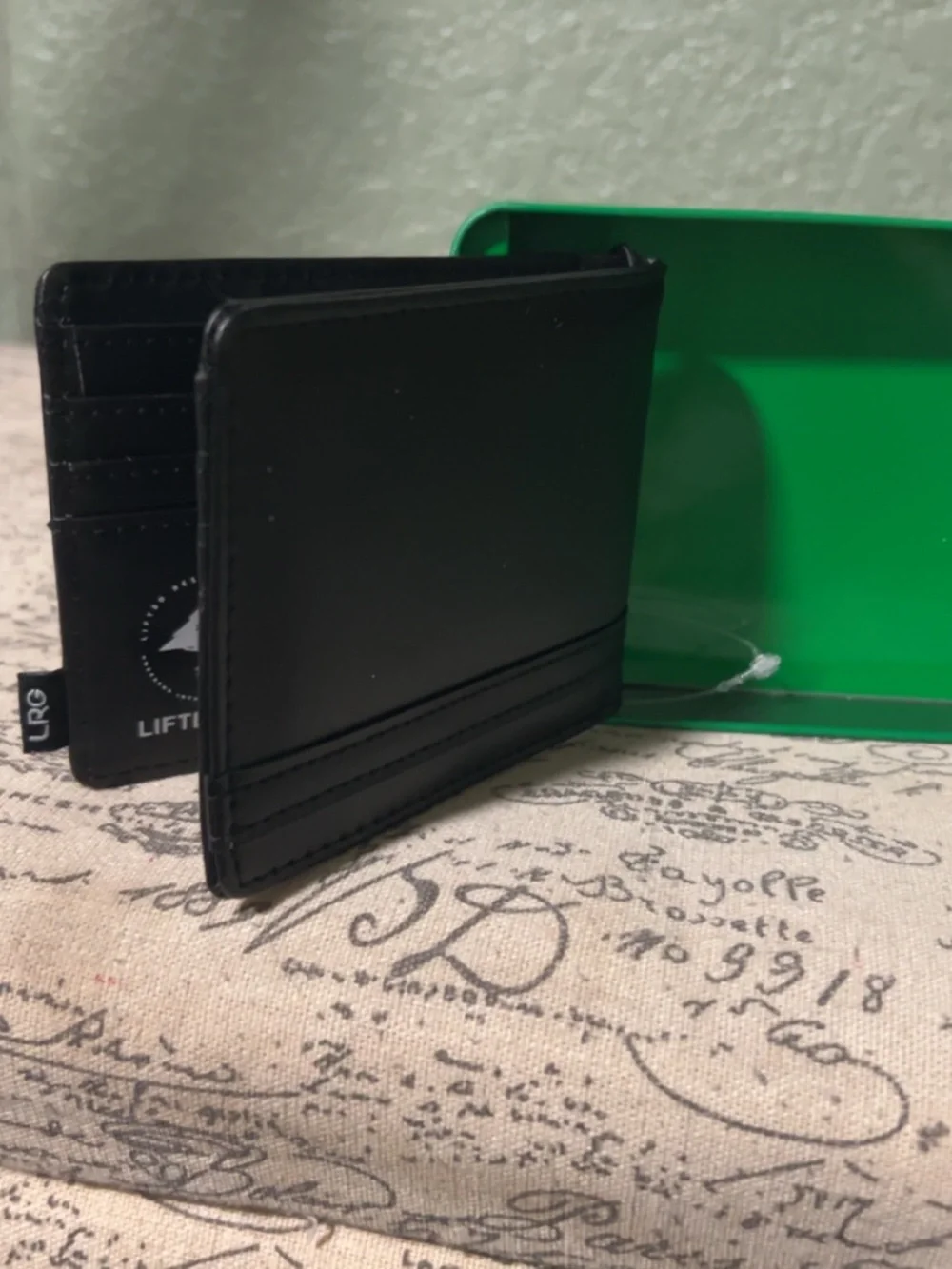 LRG Lifted Research Group black bifold wallet comes in a green branded tin